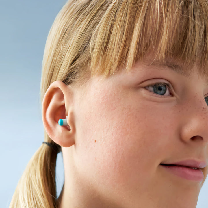 Close-up of child wearing Alpine Pluggies Kids Earplugs, offering hearing protection and a secure, comfortable fit.