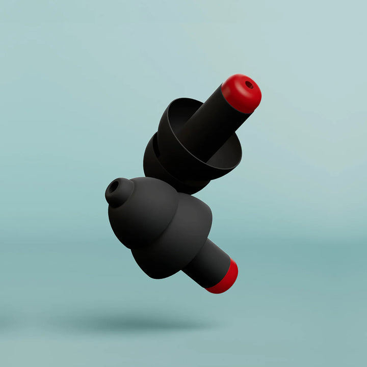 Close-up of Alpine WorkSafe earplugs showing black triple-flange design with red acoustic filter tips