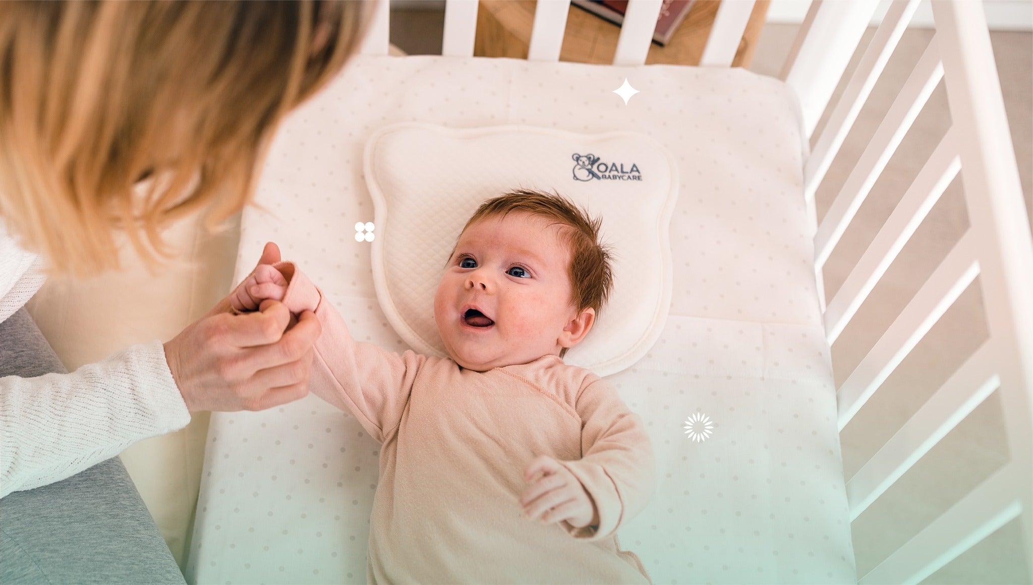 Baby lying on Koala Babycare Koala Perfect Head pillow in crib, supported and smiling