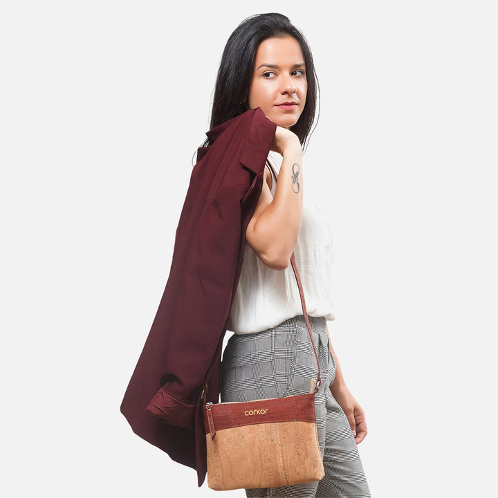 Woman wearing Corkor Vegan Cork Crossbody Bag in light brown and red, styled with business-casual outfit