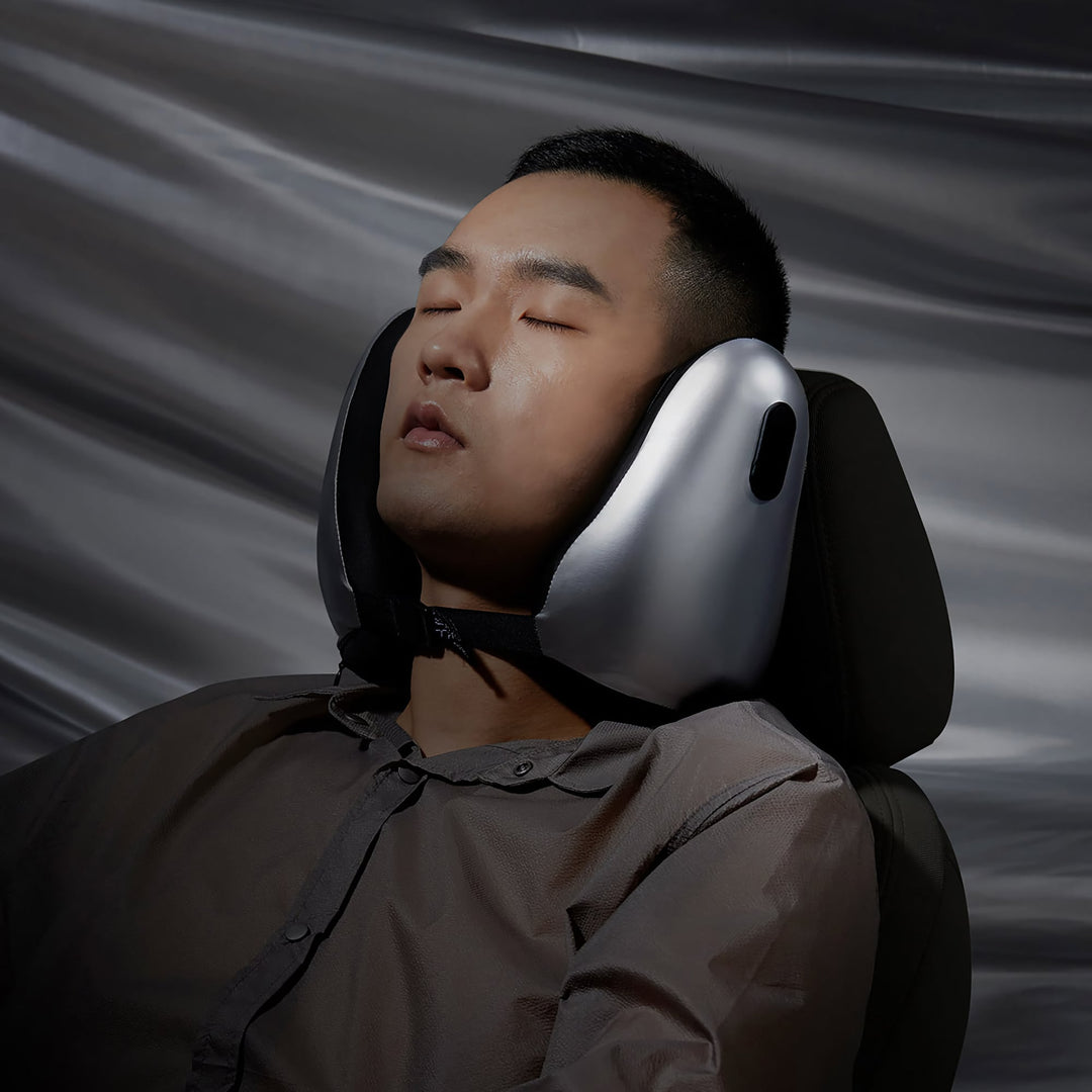 Man sleeping with EVERYTHINK E2-X metallic silver travel neck pillow on a car seat