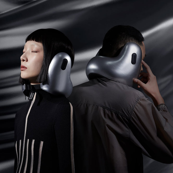 Man and woman wearing EVERYTHINK E2 X travel neck pillows in metallic silver, side-by-side view