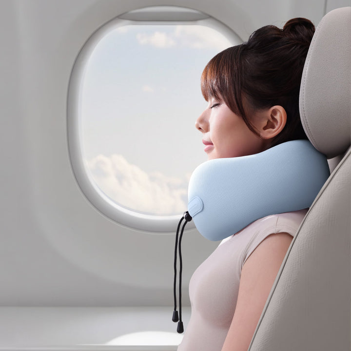 Woman resting with EVERYTHINK EC3 Clear Sky Blue neck pillow on airplane seat, enjoying in-flight support