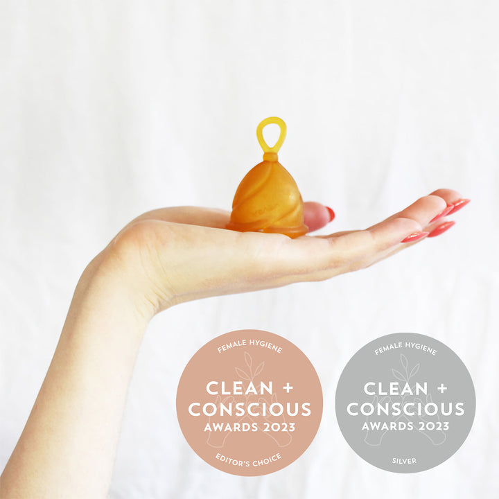 HEVEA Loop Menstrual Cup held in hand, awarded Clean + Conscious 2023 Editor's Choice and Silver in Female Hygiene