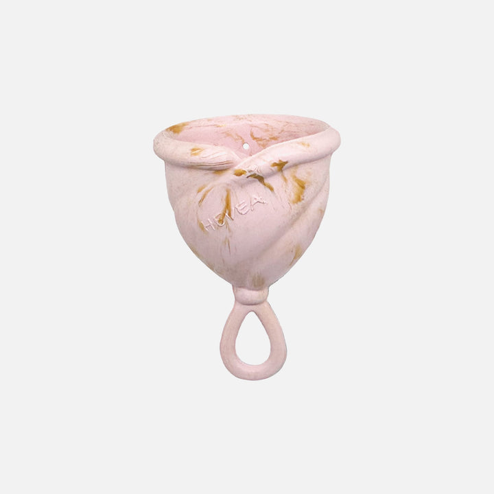 Hevea Loop Menstrual Cup in Size 1, Golden Blush color, made from soft natural rubber with loop stem for easy removal