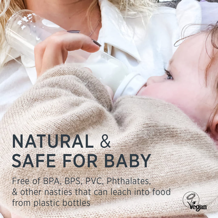 Baby drinking from a HEVEA glass bottle with a natural rubber nipple, free from BPA, BPS, PVC, and phthalates for a safe feeding experience.