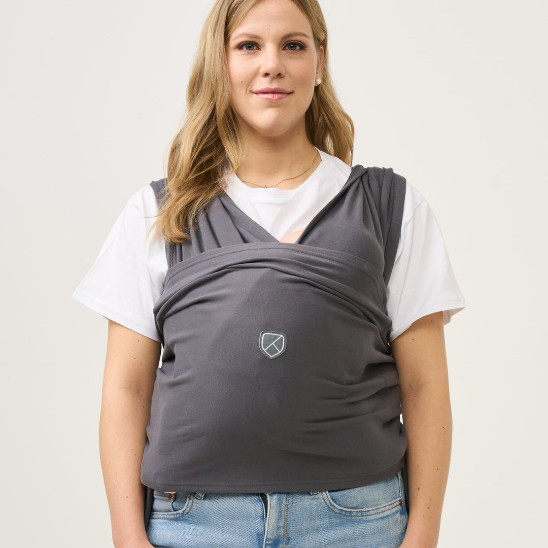 Woman wearing Koala Babycare Cuddle Band 2 in dark gray color, ideal for hands-free babywearing