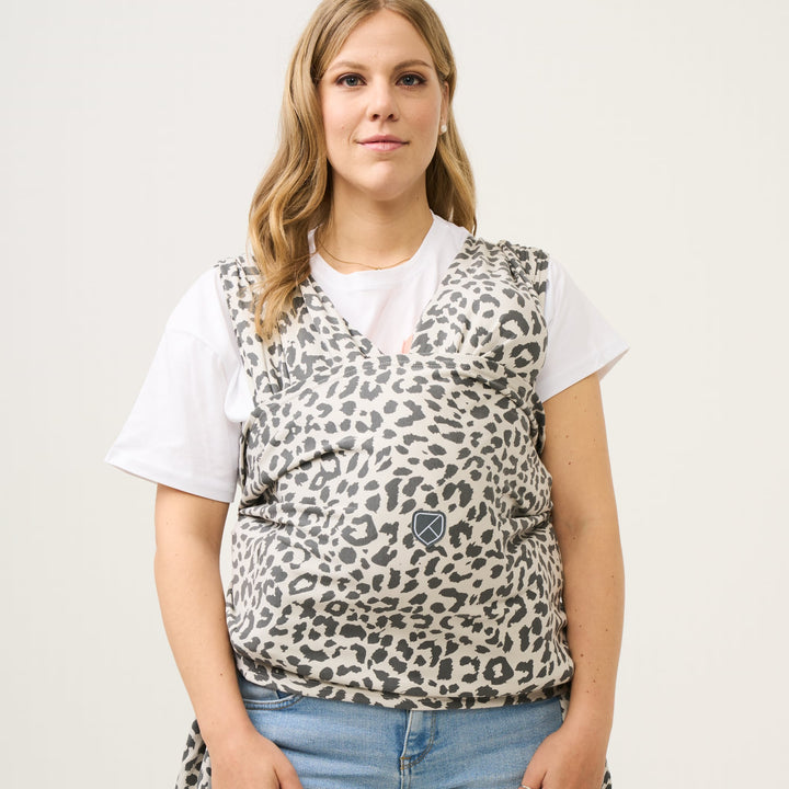 Woman wearing Koala Babycare Koala Cuddle Band 2 in leopard print, front view with baby held close