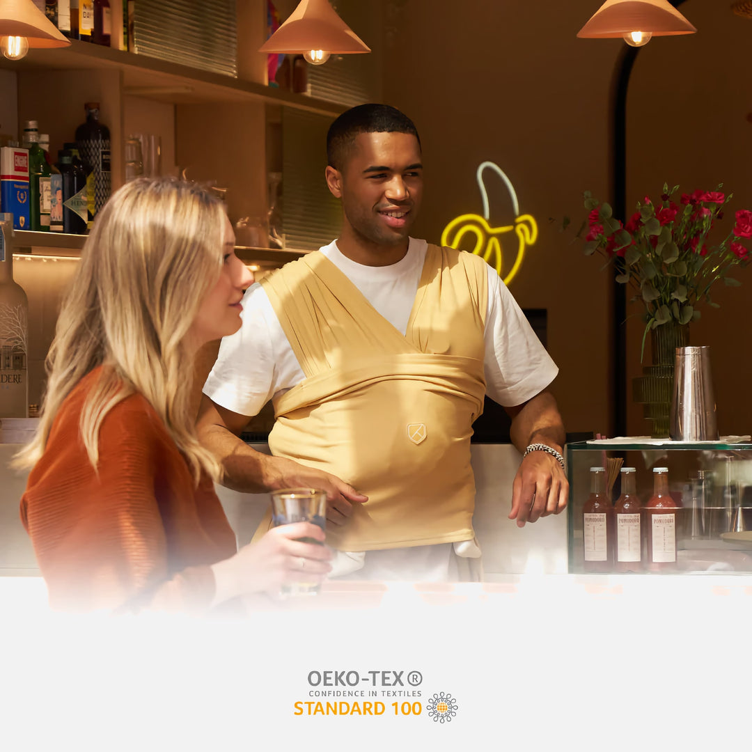 Man wearing Koala Cuddle Band 2 in mustard color in a casual café setting