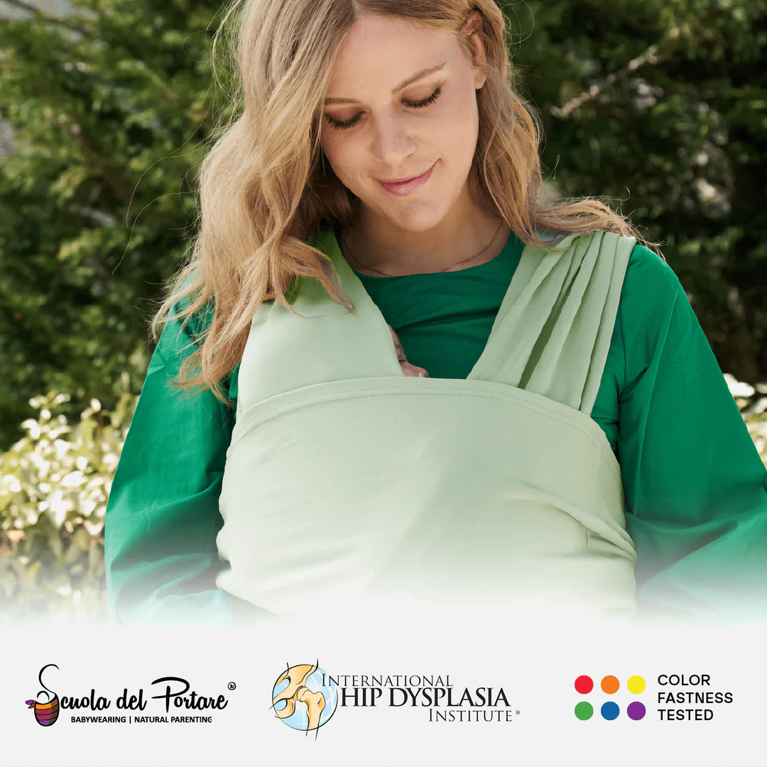 Woman wearing Koala Babycare Koala Cuddle Band 2 in sage green outdoors with baby