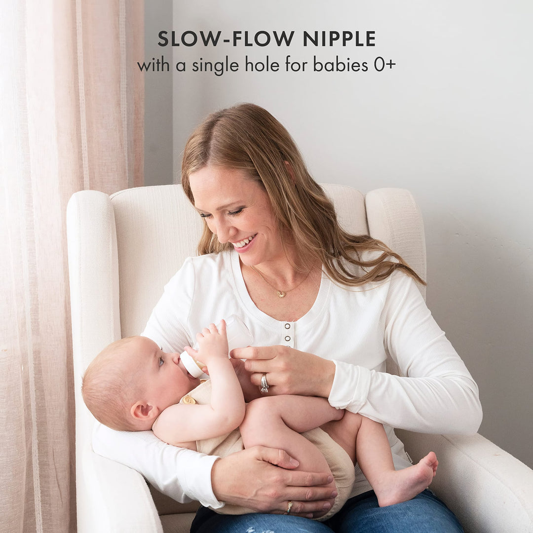 Mother feeding newborn with Natursutten glass baby bottle featuring a slow-flow nipple with single hole for babies 0+