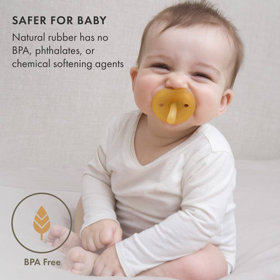 Smiling baby using Natursutten Natural Rubber Butterfly Pacifier, BPA-free, phthalate-free, and made from 100% natural rubber.