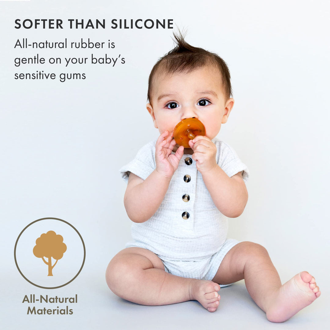 Baby holding Natursutten pacifier made from soft natural rubber, safe for sensitive gums