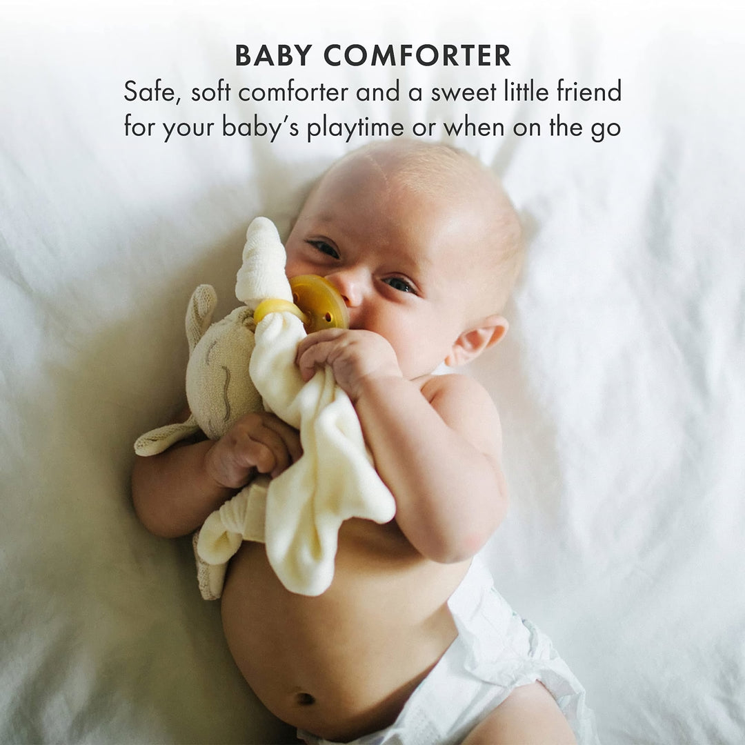 Baby holding Natursutten PaciPixy comforter with pacifier, a soft and safe companion for soothing and playtime