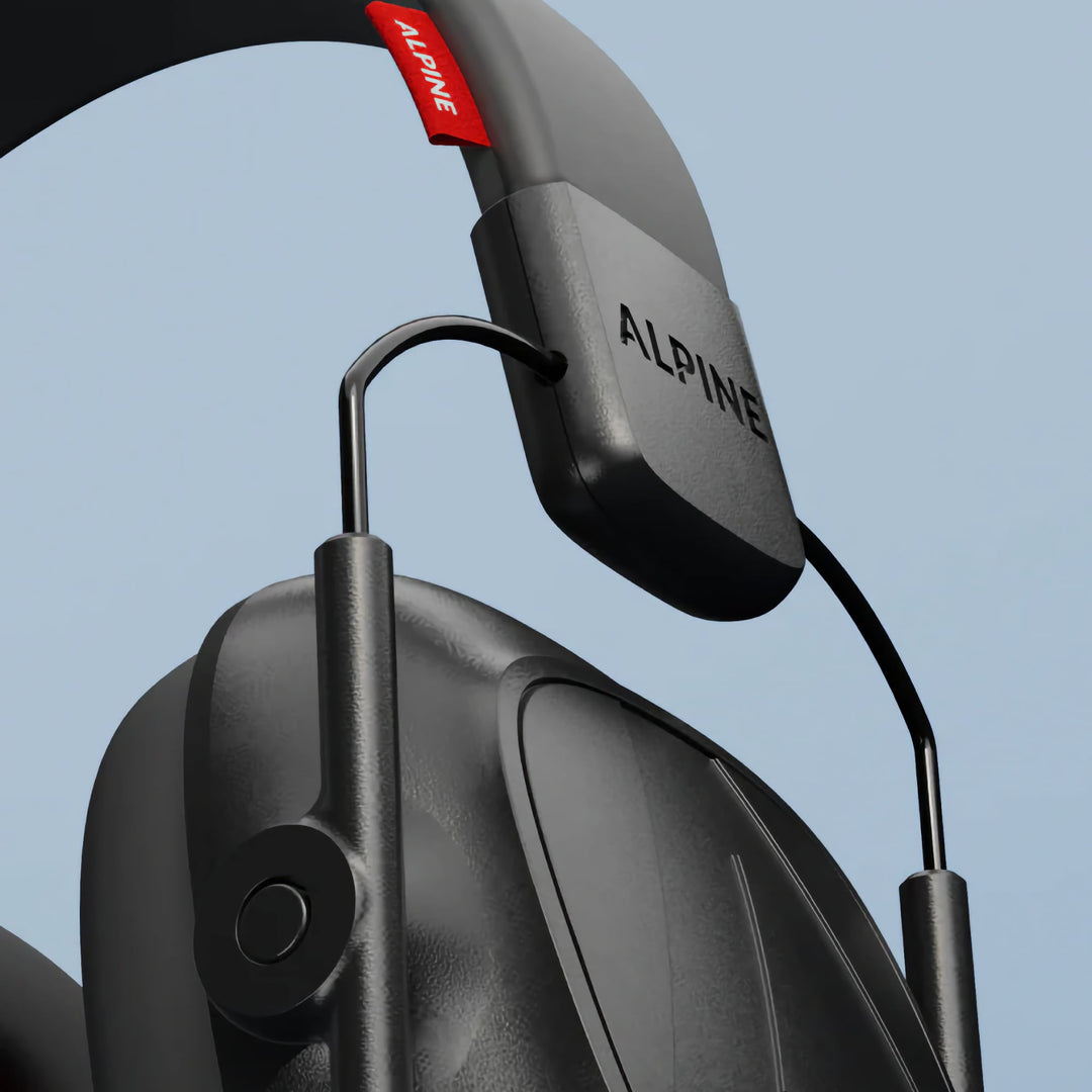 Close-up of Alpine Defender earmuffs showing adjustable headband and durable frame design