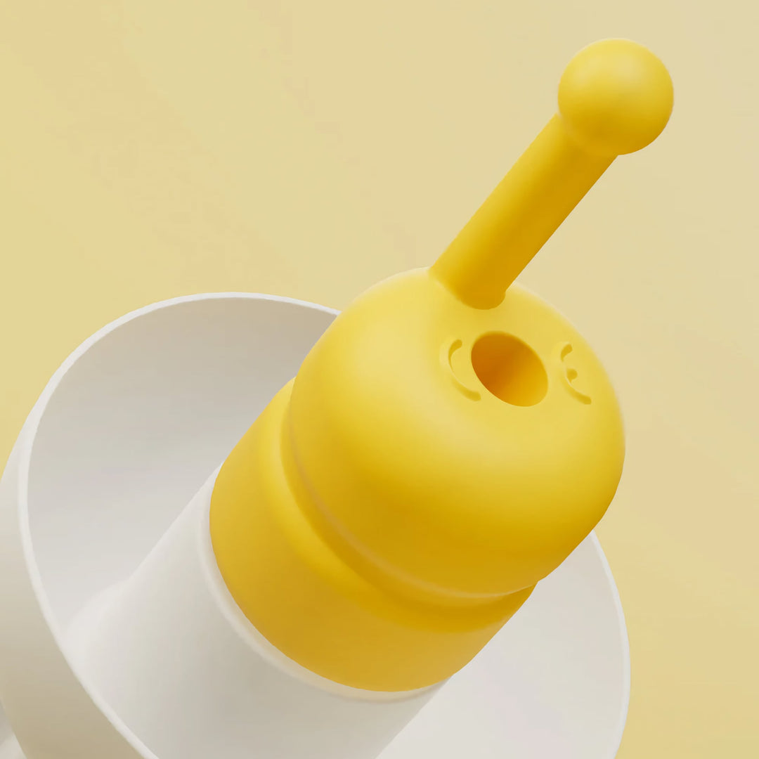 Macro close-up of Alpine FlyFit earplugs highlighting the yellow pressure-regulating filter and soft white ear tip