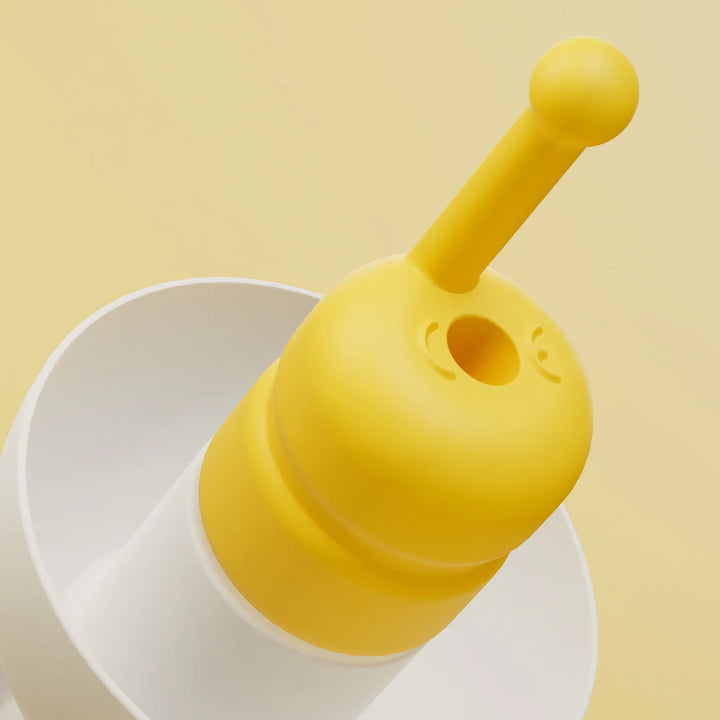 Macro close-up of Alpine FlyFit earplugs highlighting the yellow pressure-regulating filter and soft white ear tip