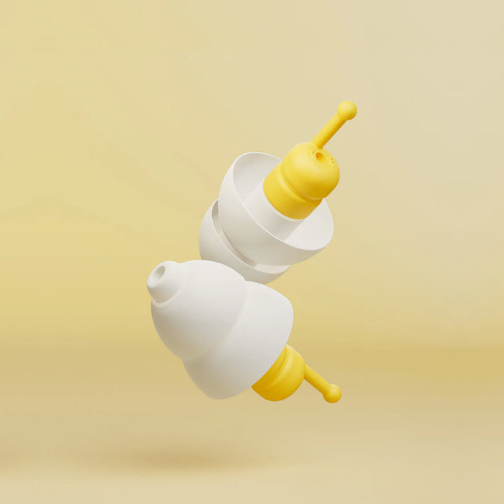 Close-up of Alpine FlyFit earplugs showing the white triple-flange tips and yellow pressure-regulating filter design