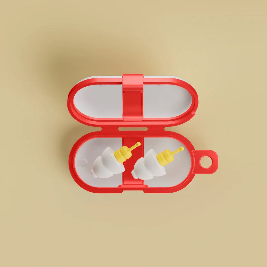 Top view of Alpine FlyFit earplugs stored in the red travel case, showing white tips and yellow pressure-regulating filters