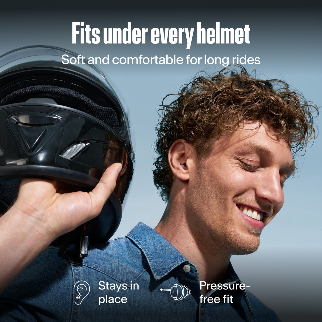 Black motorcycle earplug worn by a rider holding a helmet, shown with secure fit and pressure-free fit
