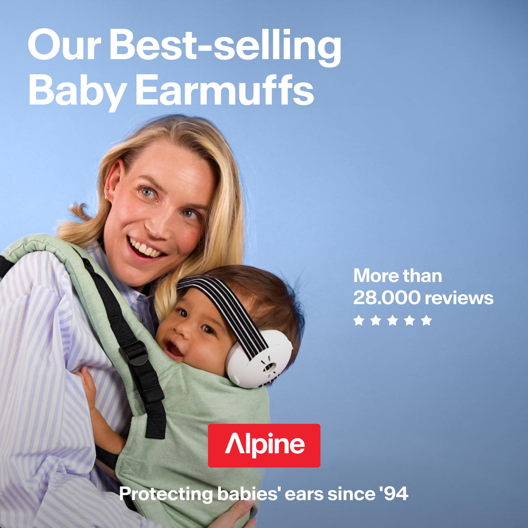 Parent carrying baby wearing white Alpine Muffy Baby Classic earmuffs with black striped headband
