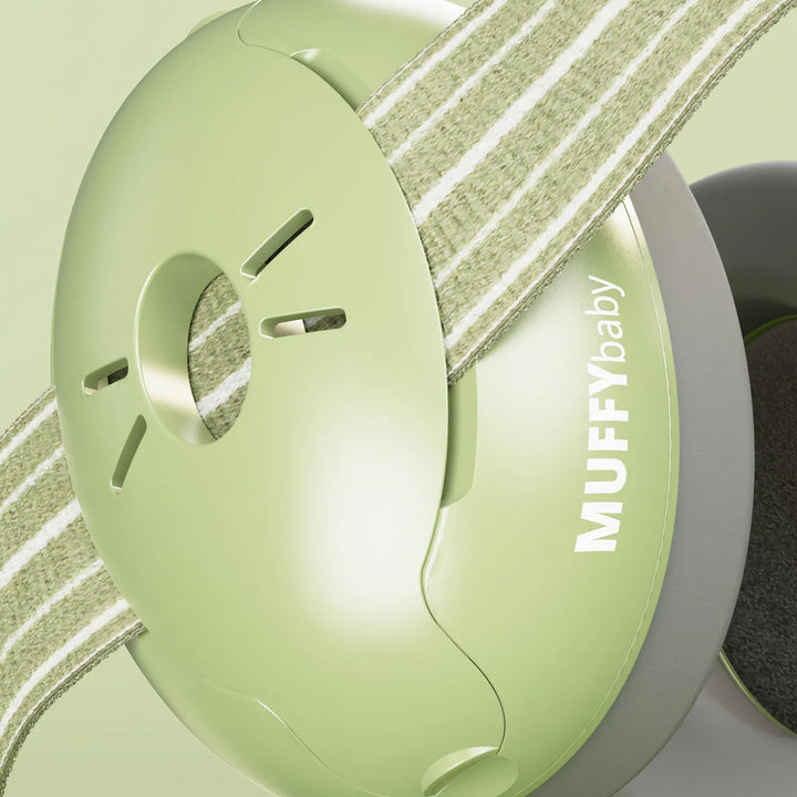 Close-up of Alpine Muffy Baby Earmuffs in green, showing the durable ear cup design and adjustable non-slip headband for comfortable infant hearing protection.