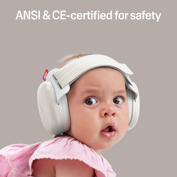 Baby wearing Alpine Muffy Baby Comfort earmuffs Soft Sand showing CE and ANSI certified infant hearing protection