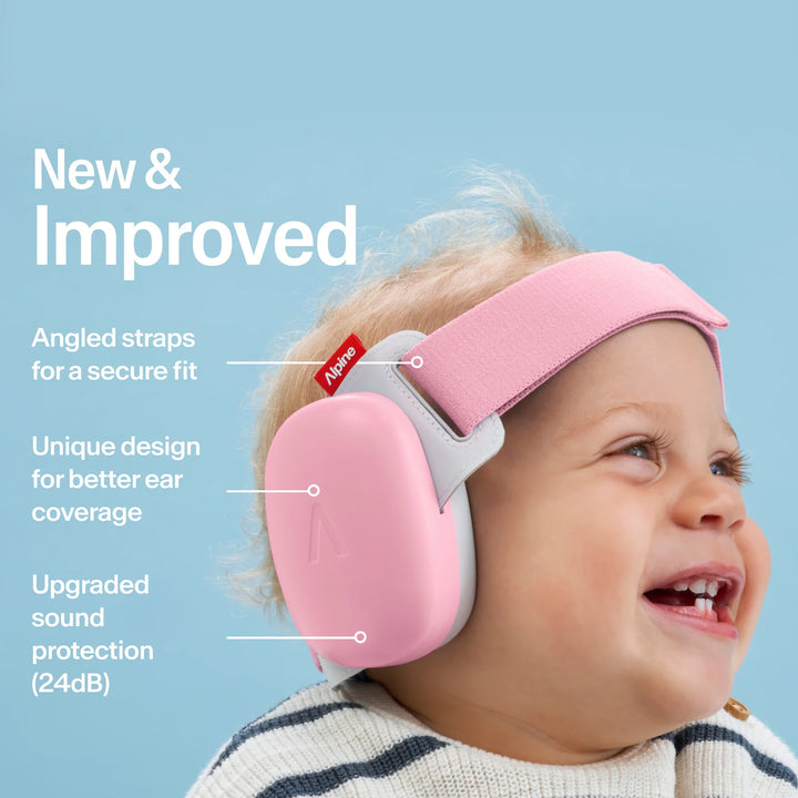 Smiling baby wearing Alpine Muffy Baby Rose Pink earmuffs with angled straps, secure fit, and 24dB certified noise protection