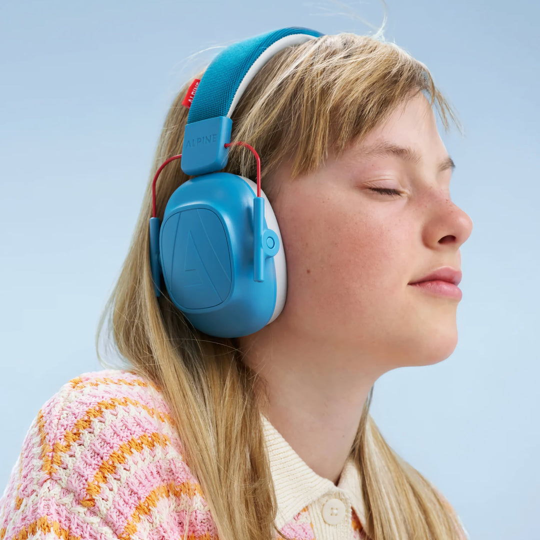 Child wearing Alpine Muffy Kids Earmuffs in blue, enjoying effective noise protection and comfort, ideal for ages 5–16 in noisy environments.