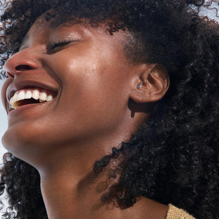 Woman wearing Alpine PartyPlug Earplugs, showcasing their discreet and comfortable fit for concerts, festivals, and nightlife protection.