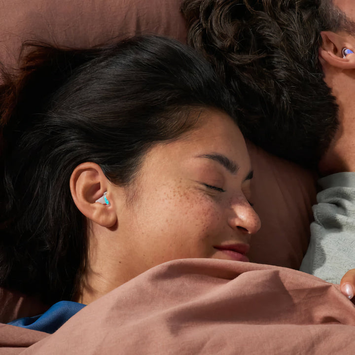 Couple sleeping peacefully with Alpine SleepDeep earplugs, highlighting noise reduction and comfort for all sleepers.