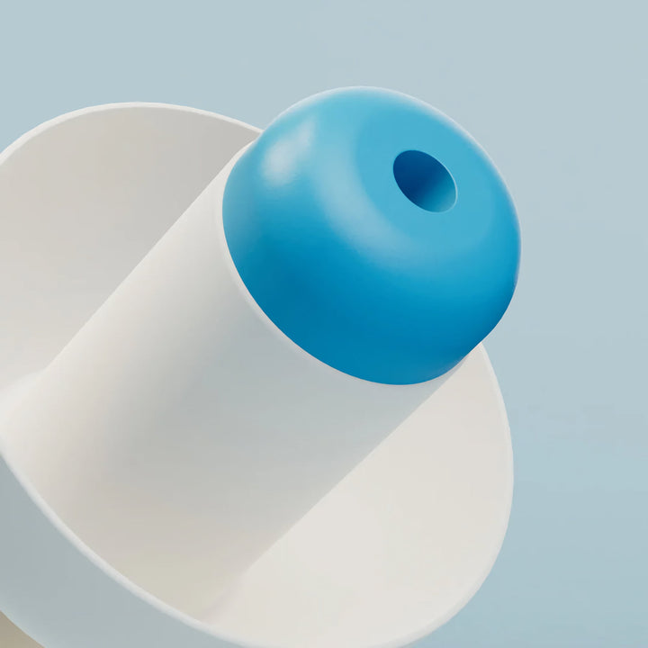 Close-up of an Alpine SwimSafe white swimming earplug showing the blue acoustic filter opening