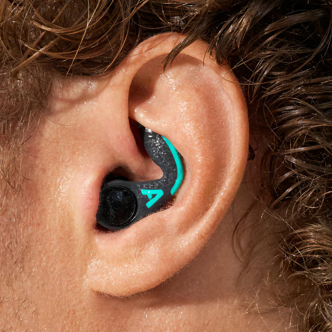 Close-up of Alpine WaterSafe Pro earplugs securely fitted in the ear, showcasing ergonomic design and water resistance.