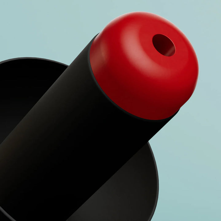 Extreme close-up of Alpine WorkSafe earplug showing red acoustic filter tip and precision detailing