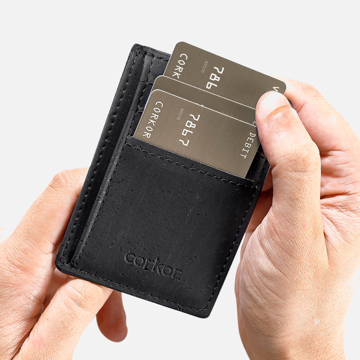 Black Corkor vegan cork RFID card wallet held in hand, showing card slots with inserted cards and minimalist design.