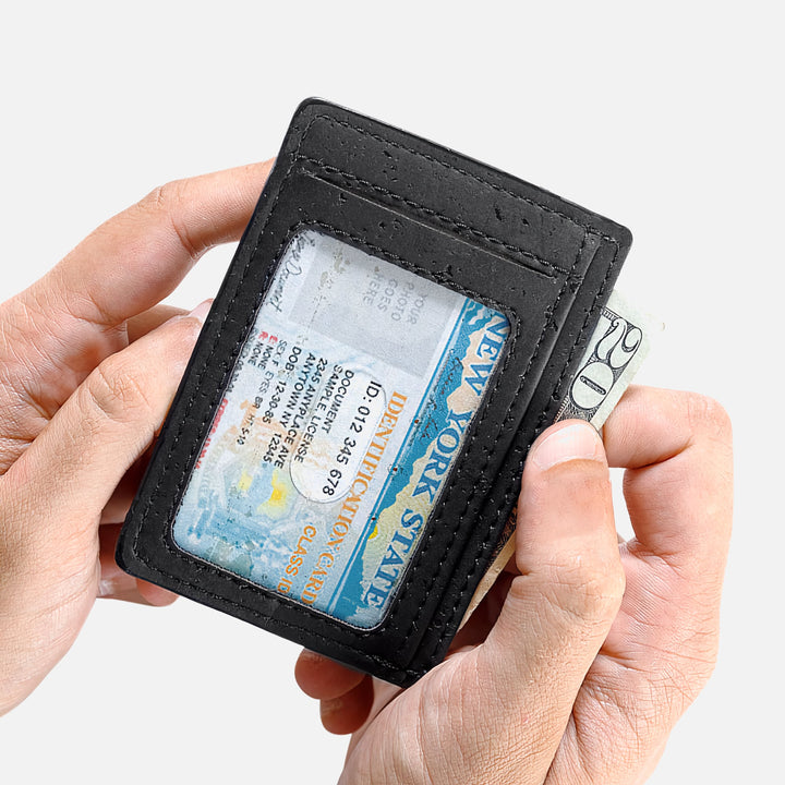 Black Corkor vegan cork RFID card wallet held in hand, featuring ID window and cash compartment in a slim design.