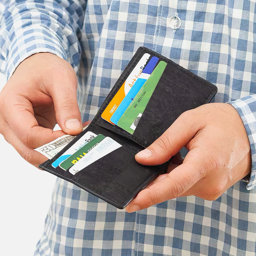 Man holding Black Corkor Vegan Cork Slim Bifold Wallet with cards inside, showcasing minimalist and functional design.