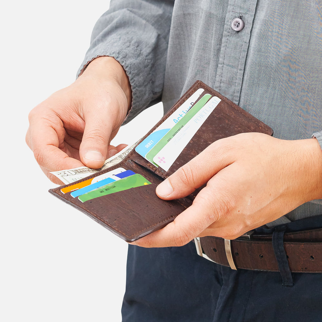 Man holding dark brown Corkor Vegan Cork Slim Bifold Wallet with cards and cash inside, highlighting functional and eco-friendly design.