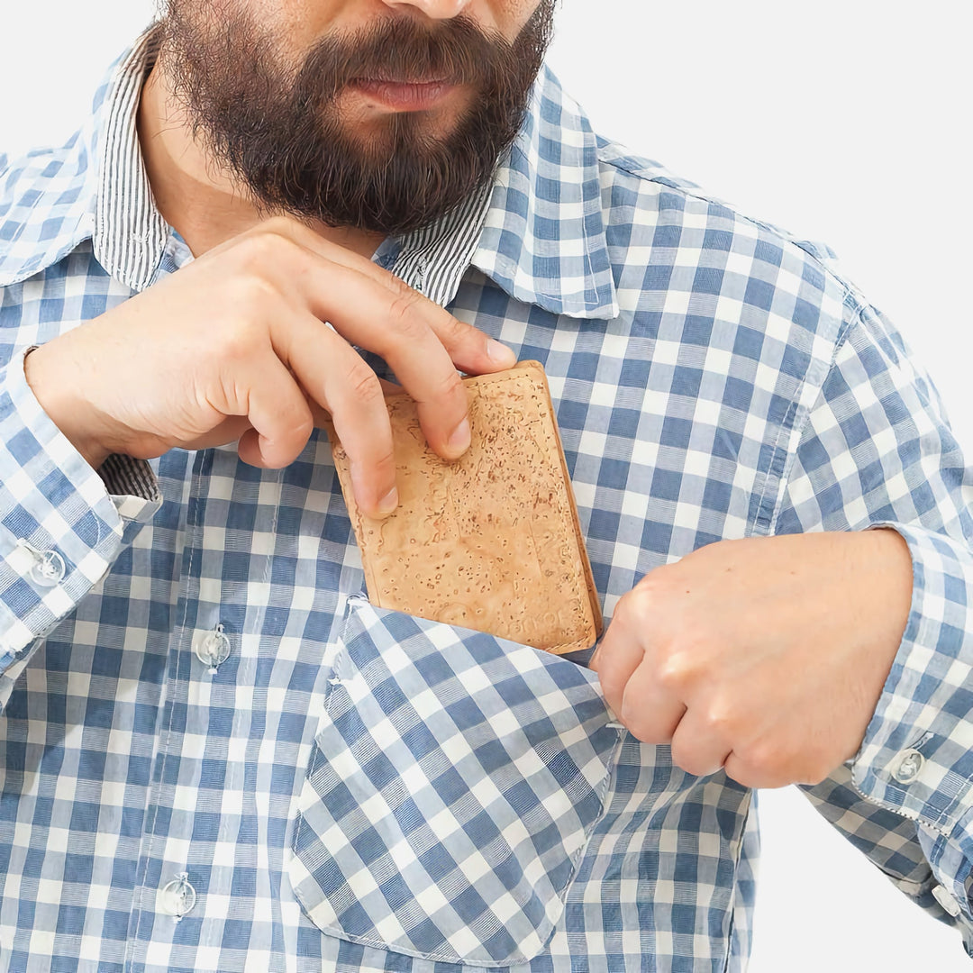 Man placing a light brown Corkor Vegan Cork Wallet into his shirt pocket, highlighting its lightweight and eco-friendly design.