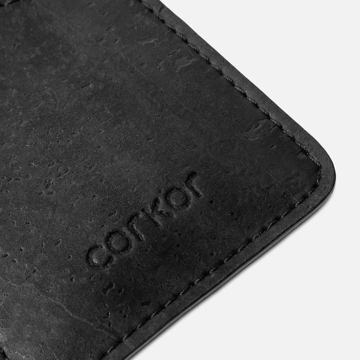 Close-up detail of the Corkor CK241 black vegan cork card sleeve wallet, showcasing the natural cork texture and debossed Corkor logo in a sustainable, minimalist design.