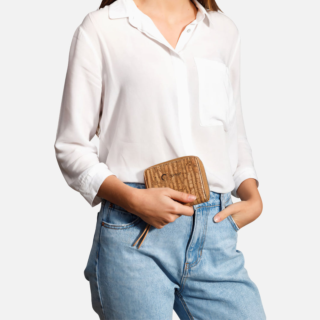 Corkor Zebra cork square wallet held by a woman wearing a white shirt and blue jeans