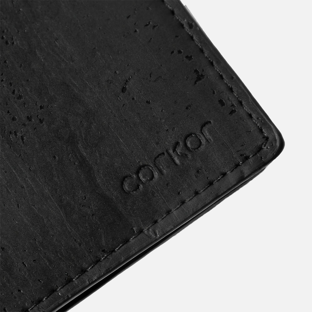 Close-up of Corkor vegan cork bifold wallet, showcasing the debossed Corkor logo on the black cork leather texture.