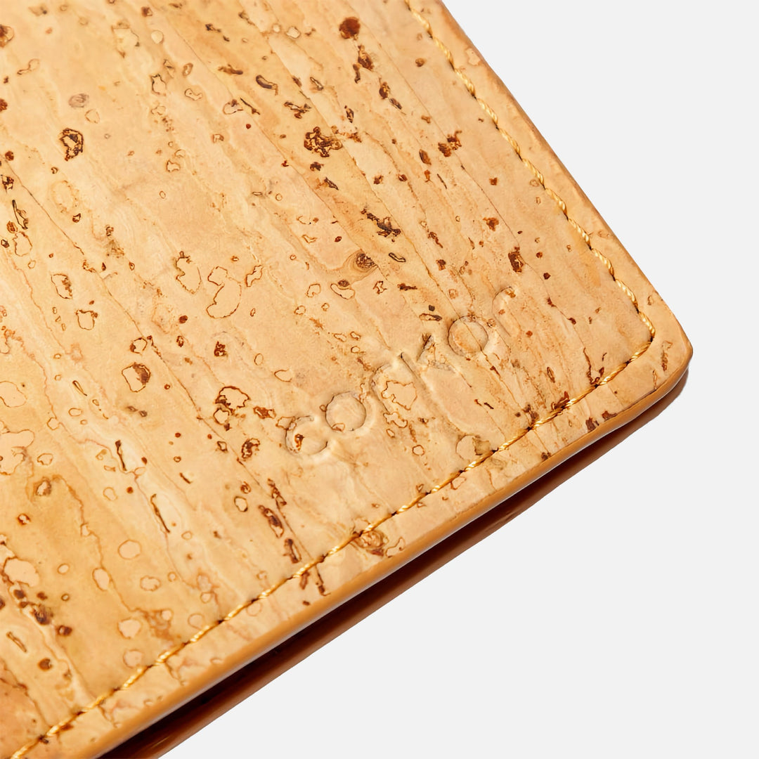 Close-up of Corkor vegan cork bifold wallet, showcasing the debossed Corkor logo on the light brown cork leather texture.