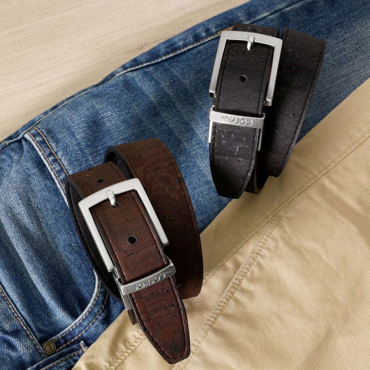 Corkor black and brown belts with silver buckles displayed on blue jeans and beige pants