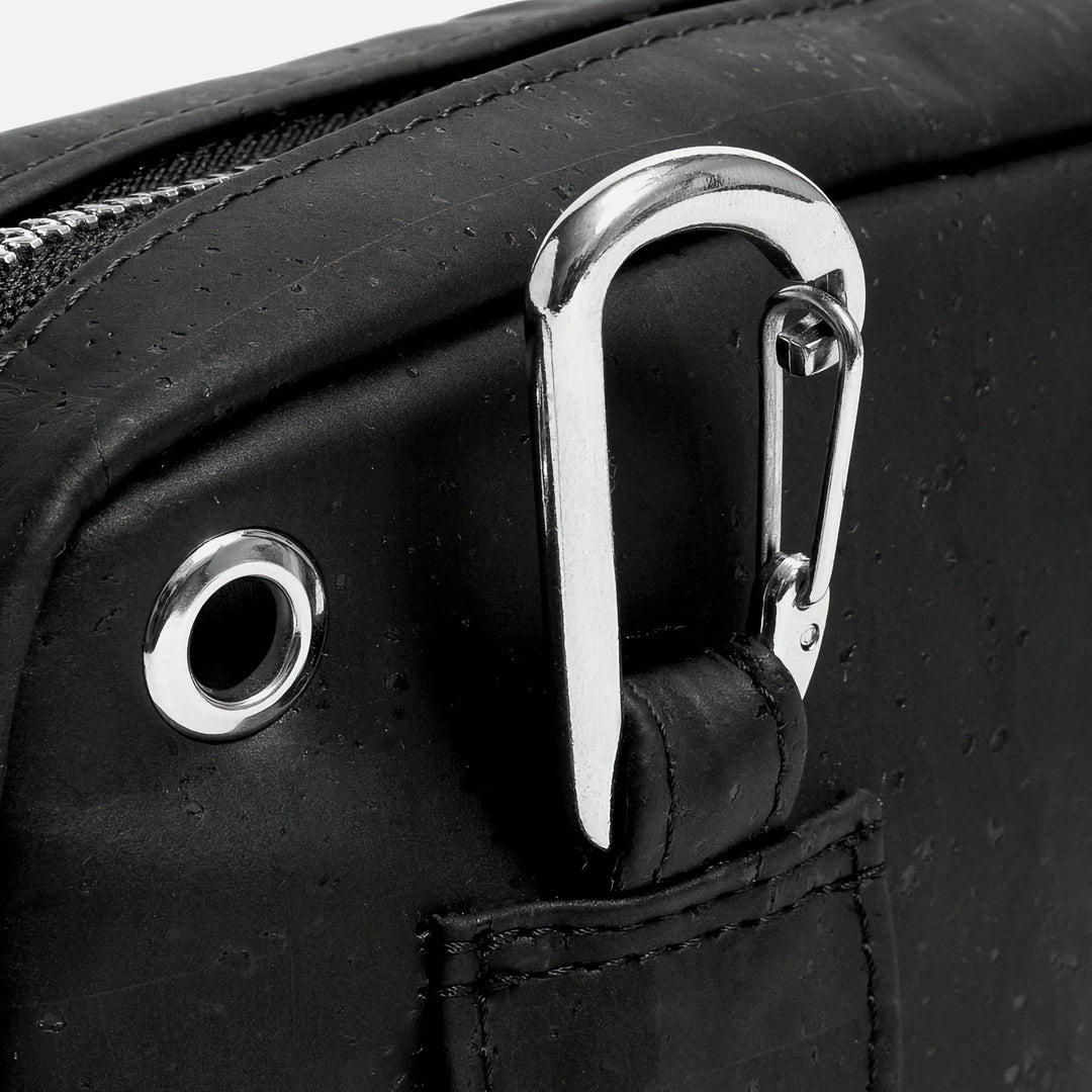 Close-up of Corkor Vegan Cork Crossbody Pouch Horizontal in black cork leather showing carabiner clip and earphone hole