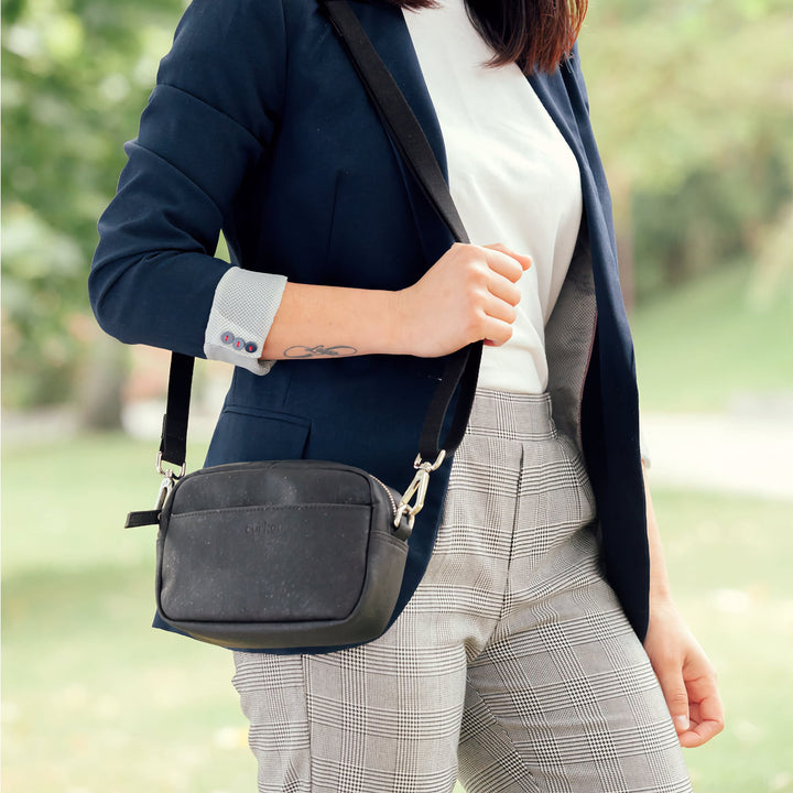 Woman wearing Corkor Vegan Cork Crossbody Pouch Horizontal in black cork leather with adjustable strap for daily use