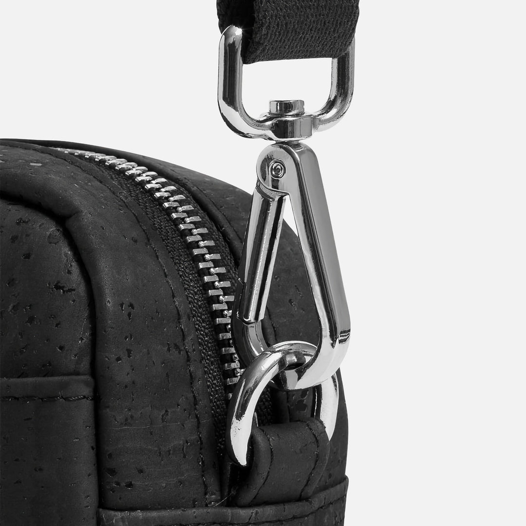 Close-up of Corkor Vegan Cork Crossbody Pouch Horizontal in black cork leather showing metal strap clip and zipper detail