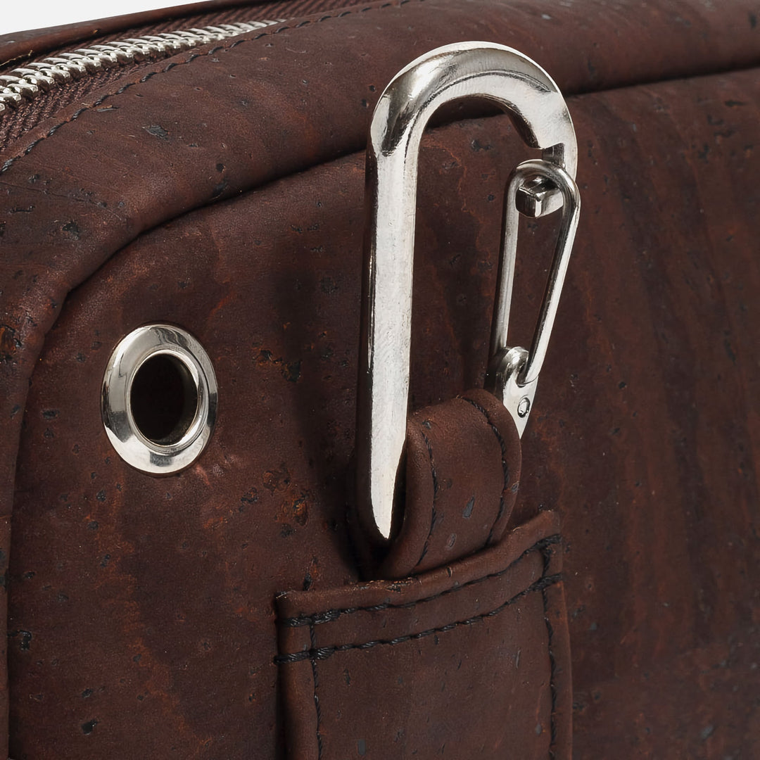 Close-up of Corkor Vegan Cork Crossbody Pouch Horizontal in dark brown cork leather showing carabiner clip and earphone hole