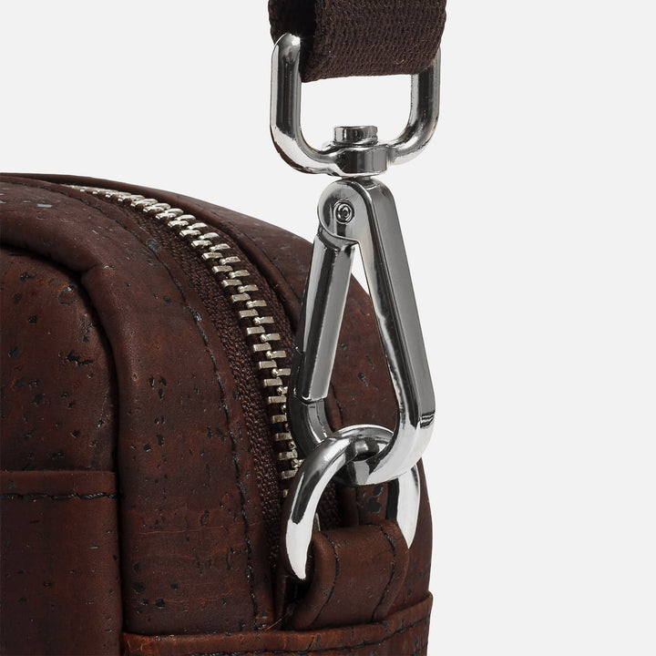 Close-up of Corkor Vegan Cork Crossbody Pouch Horizontal in dark brown cork leather showing metal strap clip and zipper detail