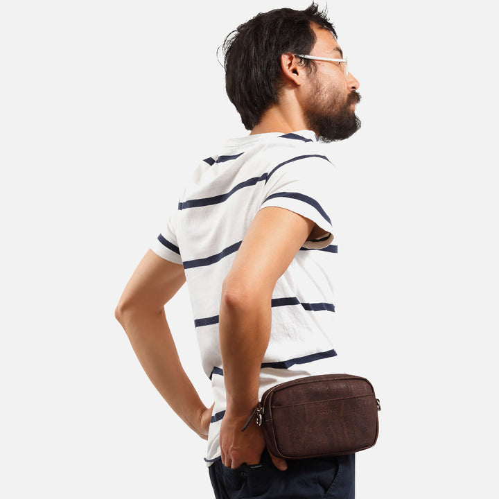 Male model wearing Corkor Vegan Cork Crossbody Pouch Horizontal in dark brown as a belt pouch for hands-free carry